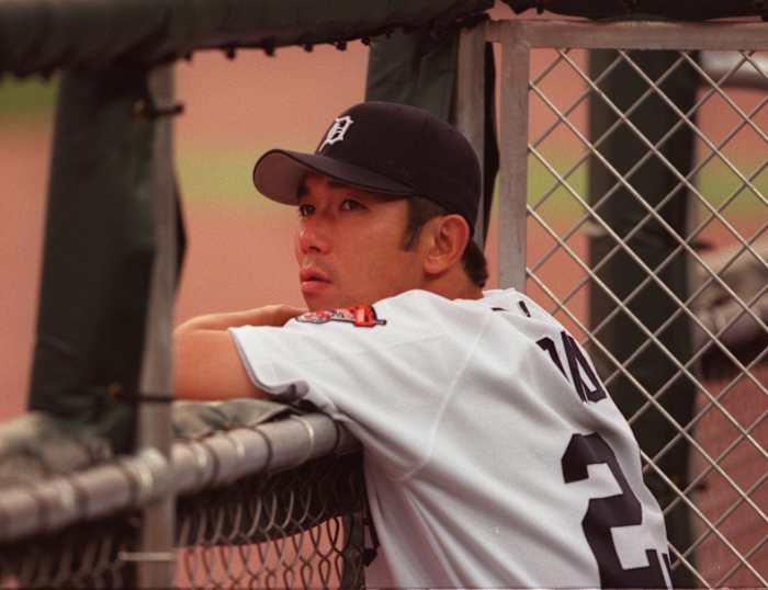 Detroit Tigers pitcher Hideo Nomo watches the game from the dugout.